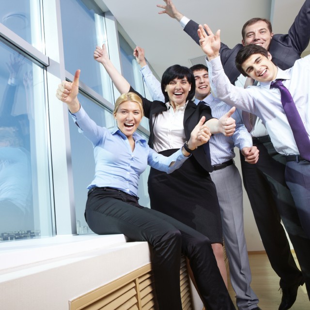 Cheerful businesspeople showing thumbs up sign 